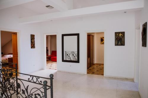 a living room with white walls and a mirror at Hotel Bela Kuka in Bitola
