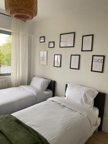 2 letti in una camera con immagini a parete di La maison de Julien a Bourbourg