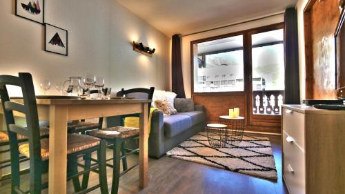 une cuisine et un salon avec une table et un canapé dans l'établissement Le Refuge de Lu', à Tignes