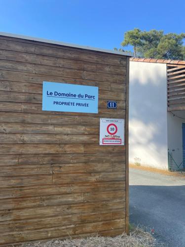 a wooden fence with a sign on top of it at L'étoile des pins in Longeville-sur-Mer