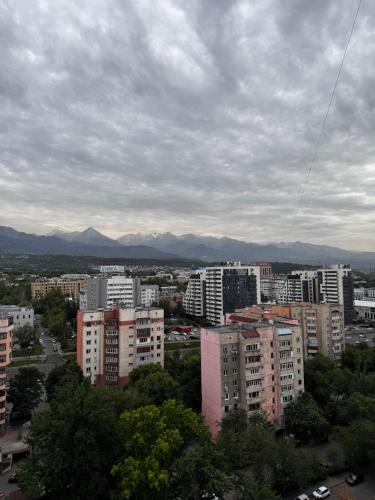 a view of a city with buildings and mountains at Samal deluxe in Almaty