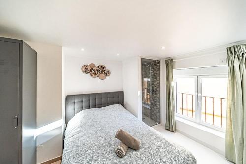 Un dormitorio con una cama y una ventana grande. en Cocon moderne Émile Zola, en Villeurbanne