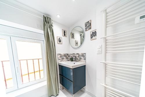 un baño con lavabo y espejo en Cocon moderne Émile Zola, en Villeurbanne