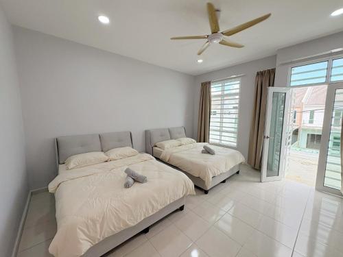 Sungai MatiにあるRasa Sayang Homestay Bukit Gambirのベッド2台と天井ファン付きの寝室