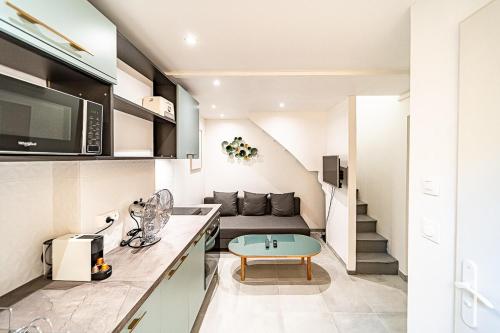 une cuisine et un salon avec un canapé et une table dans l'établissement Cocon moderne Émile Zola, à Villeurbanne