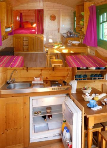 une petite cuisine avec un évier et une cuisinière dans l'établissement La Roulotte 4pl confort Au bord de la Rivière, à Laguépie