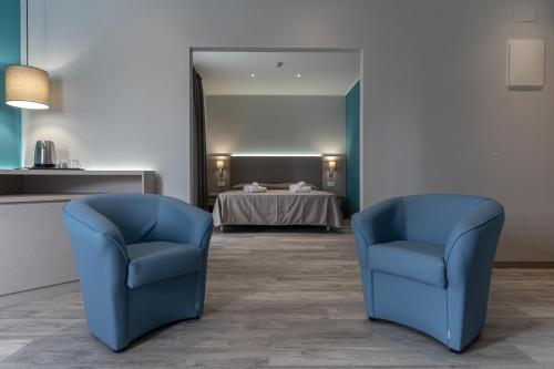 two blue chairs in a waiting room with a table at Hotel Cristina in Rimini