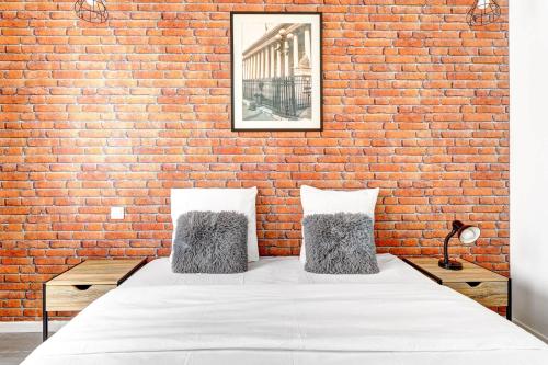 une chambre avec un mur de briques et un lit dans l'établissement Maison dartiste a proximite de la gare de Lyon, à Paris