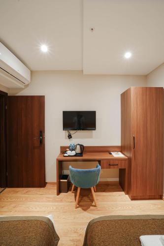 a room with a desk and a blue chair at Boutique Hotel Kviria in Tʼelavi