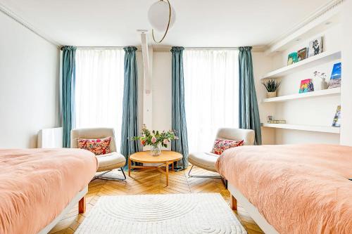 une chambre avec deux lits et une table et des chaises dans l'établissement Appartement de Luxe et Lumineux saint honore pour 6 personnes, à Paris