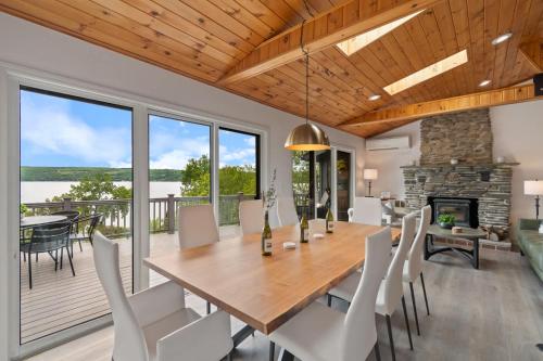 a dining room with a table and chairs and a fireplace at The Gallagher House - Speakeasy Firepit Lakeview in Hammondsport
