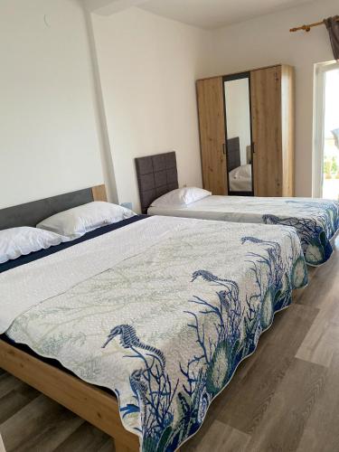 a bedroom with two beds and a mirror at Beach Apartments Luka in Tribanj-Krušćica