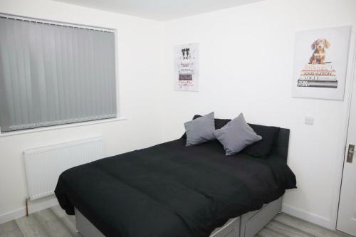 a bedroom with a black bed with two pillows at 5BDR Spacious En-suite Accomodation in Coventry