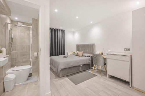 a bedroom with a bed and a bathroom with a shower at Bricklane Apartment in London