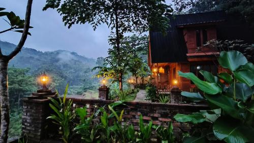 a house in the middle of a forest with lights at Villa Hening Senja Borobudur in Kayuares