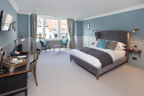 a bedroom with a bed and a table and chairs at The George Townhouse in Shipston on Stour