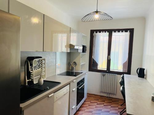 une cuisine avec un évier et une cuisinière four supérieur dans l'établissement Soleil confort riquier & Espace 4 P tout equipé, à Nice