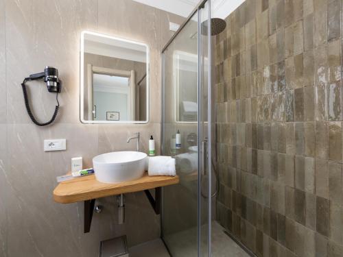 a bathroom with a sink and a glass shower at Hotel Gardenia Sorrento, Ascend Hotel Collection in Sorrento