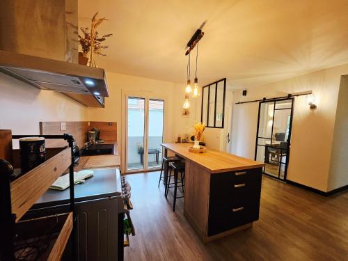 a kitchen with a counter and a dining room at Maison paisible proche centre avec piscine in Angoulême