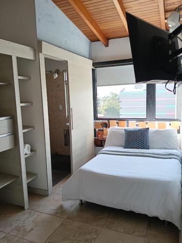 a bedroom with a bed and a large window at Tauro Black Suites Cerca al estadio Atanasio Girardot in Medellín