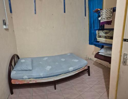 a small bed in a room with a blue mattress at Yanzz Homestay in Kampong Sorosob