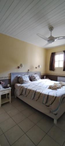 une chambre avec un grand lit avec un plafond dans l'établissement Les Hauts de Cabanoule Générargues, à Générargues