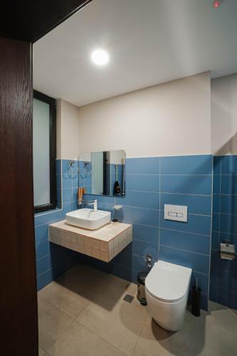 a blue bathroom with a toilet and a sink at Boutique Hotel Kviria in Tʼelavi