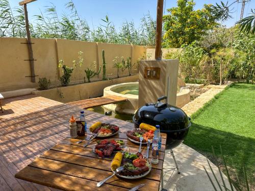 a grill on a wooden table with plates of food at Waterside Loft -Rustic & Lux Tunis Artisan Village in Tunis