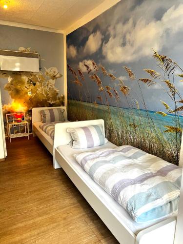 two beds in a room with a painting on the wall at Ferienwohnung in Ediger Eller in Ediger-Eller