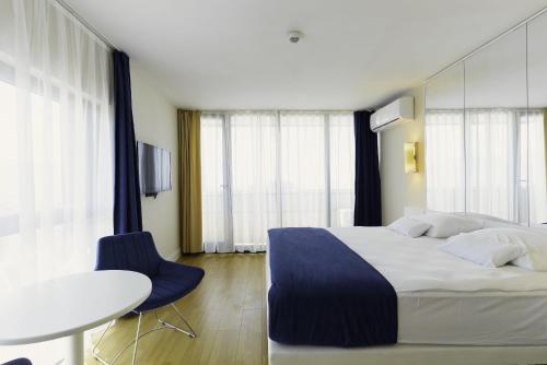 a bedroom with a large bed and a table and chairs at Batumi Orbi Super Apartments in Batumi
