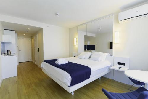 a bedroom with a large white bed and a bathroom at Batumi Orbi Super Apartments in Batumi
