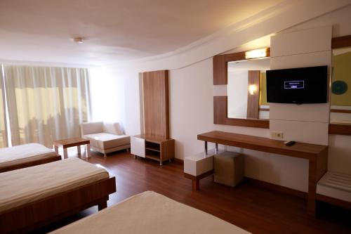 a hotel room with two beds and a television at Club Golf Hotel All Inclusive in Side