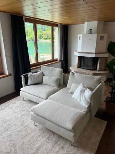 a living room with two white couches and a fireplace at Apartment 18 am Brienzersee in Brienz