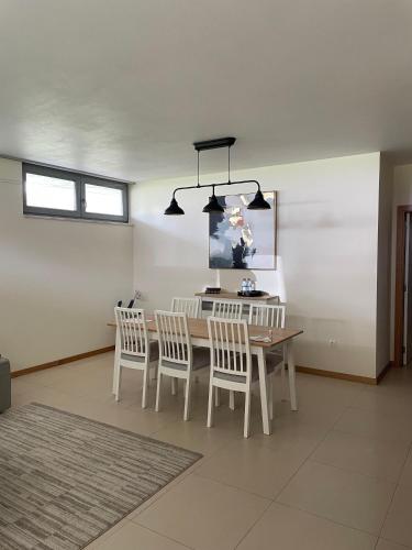 a dining room with a table and chairs and a chandelier at Refúgio da praia in Tocha