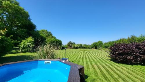 - une piscine au milieu d'une pelouse dans l'établissement casa de invitados estilo normandie, à Chamblac