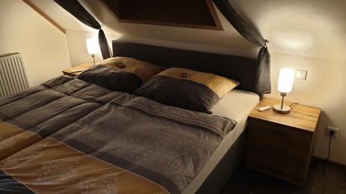 a bedroom with a bed and two lamps on a nightstand at Ferienwohnung Himmelblick in Burgoberbach