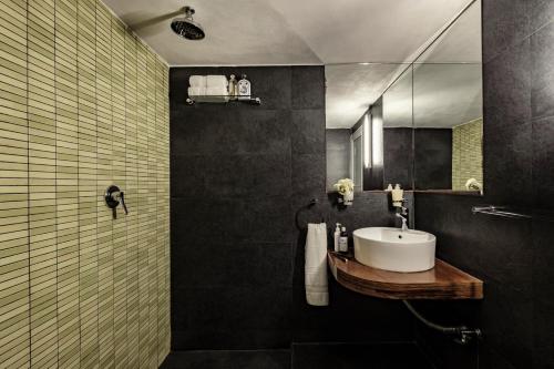 a bathroom with a sink and a mirror at Valletta Nobile by VALLETTA SUITES - a 400-year-old designer apartment in Valletta in Valletta