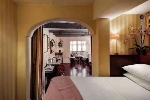a bedroom with a bed and a dining room at Valletta Nobile by VALLETTA SUITES - a 400-year-old designer apartment in Valletta in Valletta