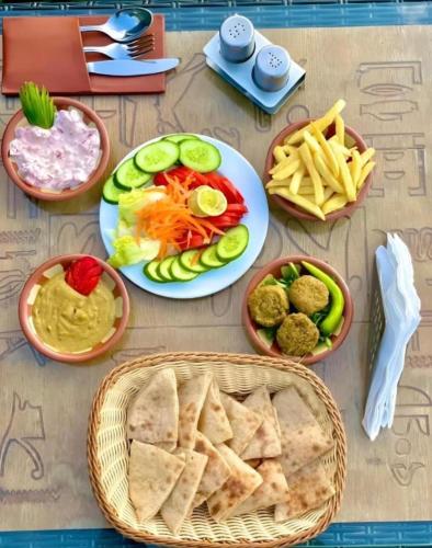 a table topped with plates of food and dips at Isis pyramids in Giza