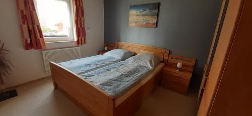 a bedroom with a bed in a room with a window at Kleines Ferienhaus Heyne in Rerik