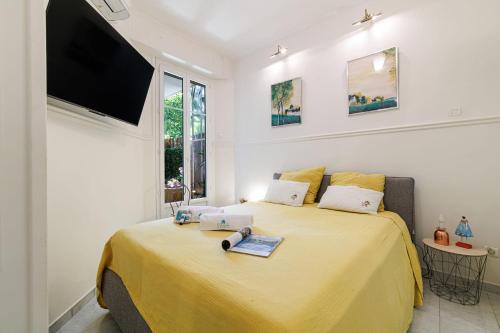 - une chambre avec un lit jaune et une télévision à écran plat dans l'établissement SAINT PHILIPPE 7 - Superb City Center Suite Apartment, à Nice
