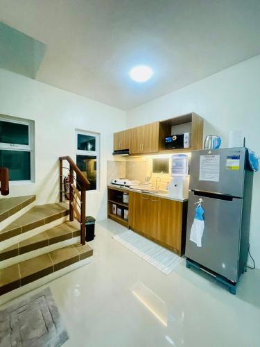 a kitchen with a stainless steel refrigerator and stairs at Staycation House in Dauis in Dauis