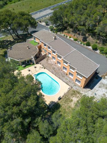 une vue aérienne d'une maison avec piscine dans l'établissement Hotel Les Rocailles, à Montagnac