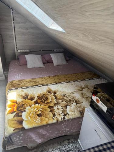 Una pequeña cama con flores en una habitación. en KendovDvorec, en Chişinău