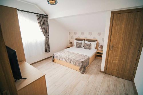 a bedroom with a bed and a window and a television at HolidayHouse-Navodari in Năvodari