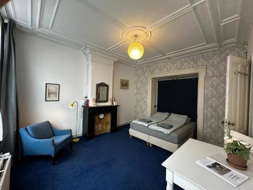a bedroom with a bed and a chair and a table at De Stijlkamer in Amsterdam