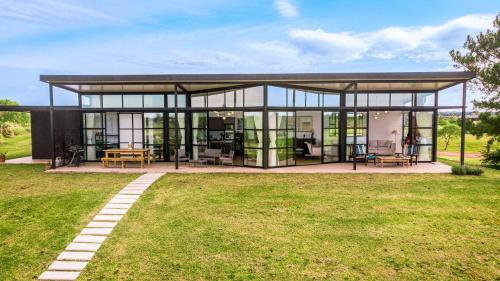 a large glass house with a patio in a yard at La Casa de Cristal by Puerto Dijama in Carmelo