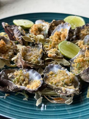 a plate of food with oysters and limes on it at Rock and Sea Resort in Watamu