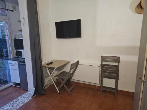 Cette chambre dispose d'un bureau et d'une télévision murale. dans l'établissement Studio Jardin Argelès plage, à Argelès-sur-Mer