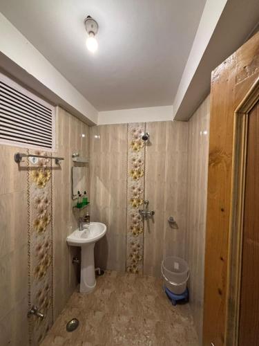 a bathroom with a sink and a shower at Asha Cottage in Manāli
